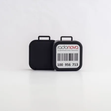 Détecteur alpha-track noir de la trousse Radtrak3, posé sur fond blanc